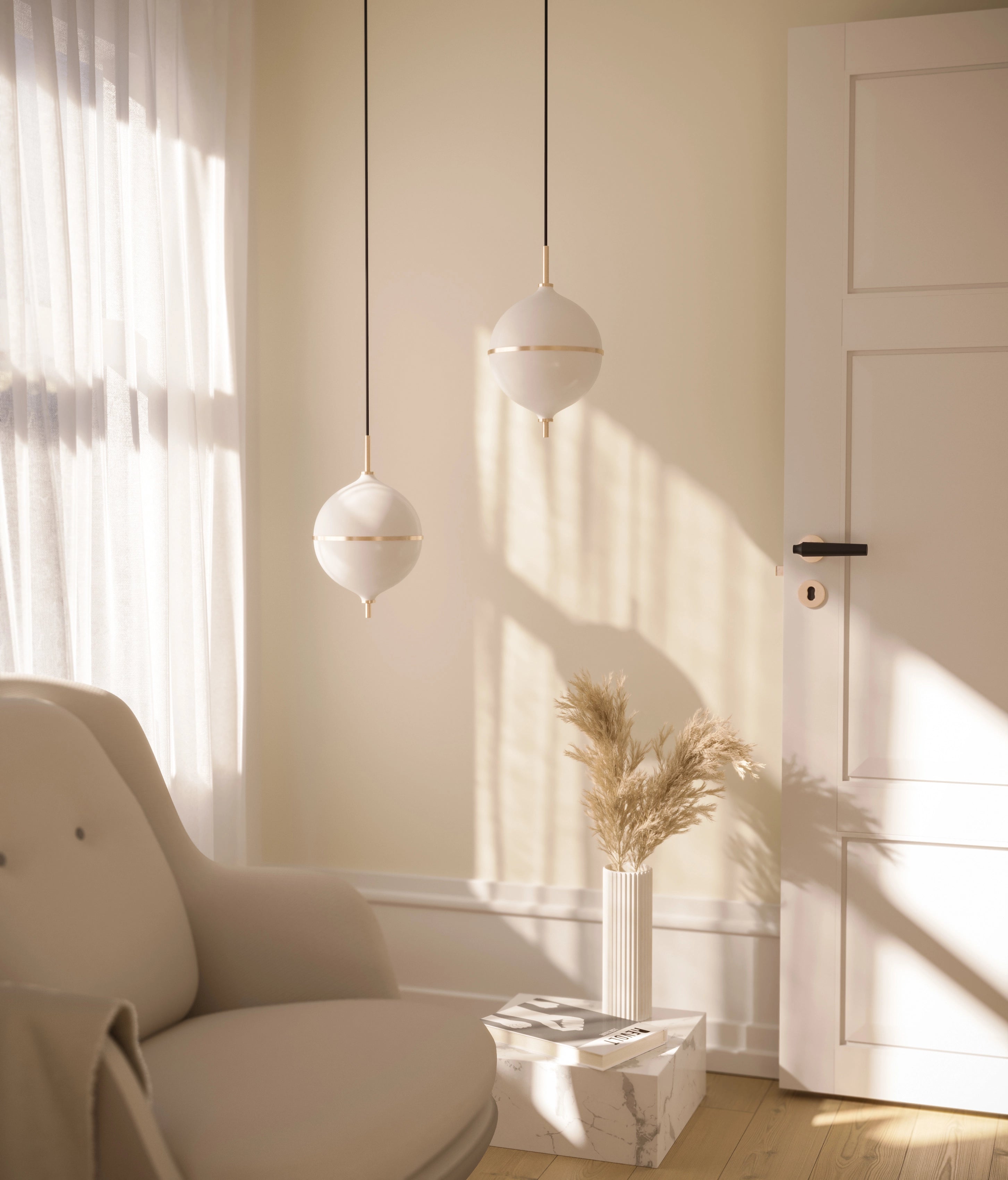 Modern interior with a beige armchair, white pendant lights, and a vase with dried plants.