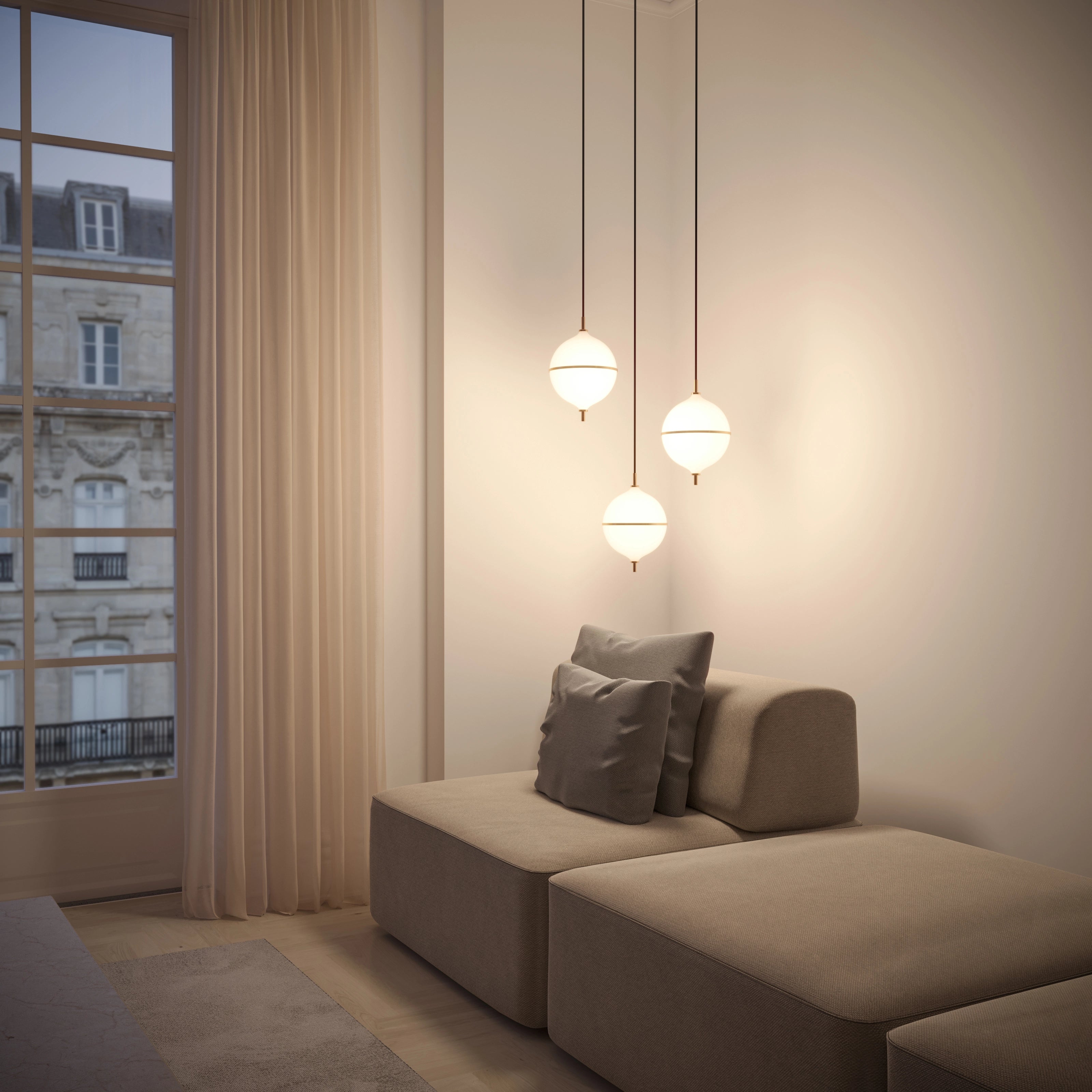 Modern living room with a beige sofa, decorative pillows, and pendant lights.