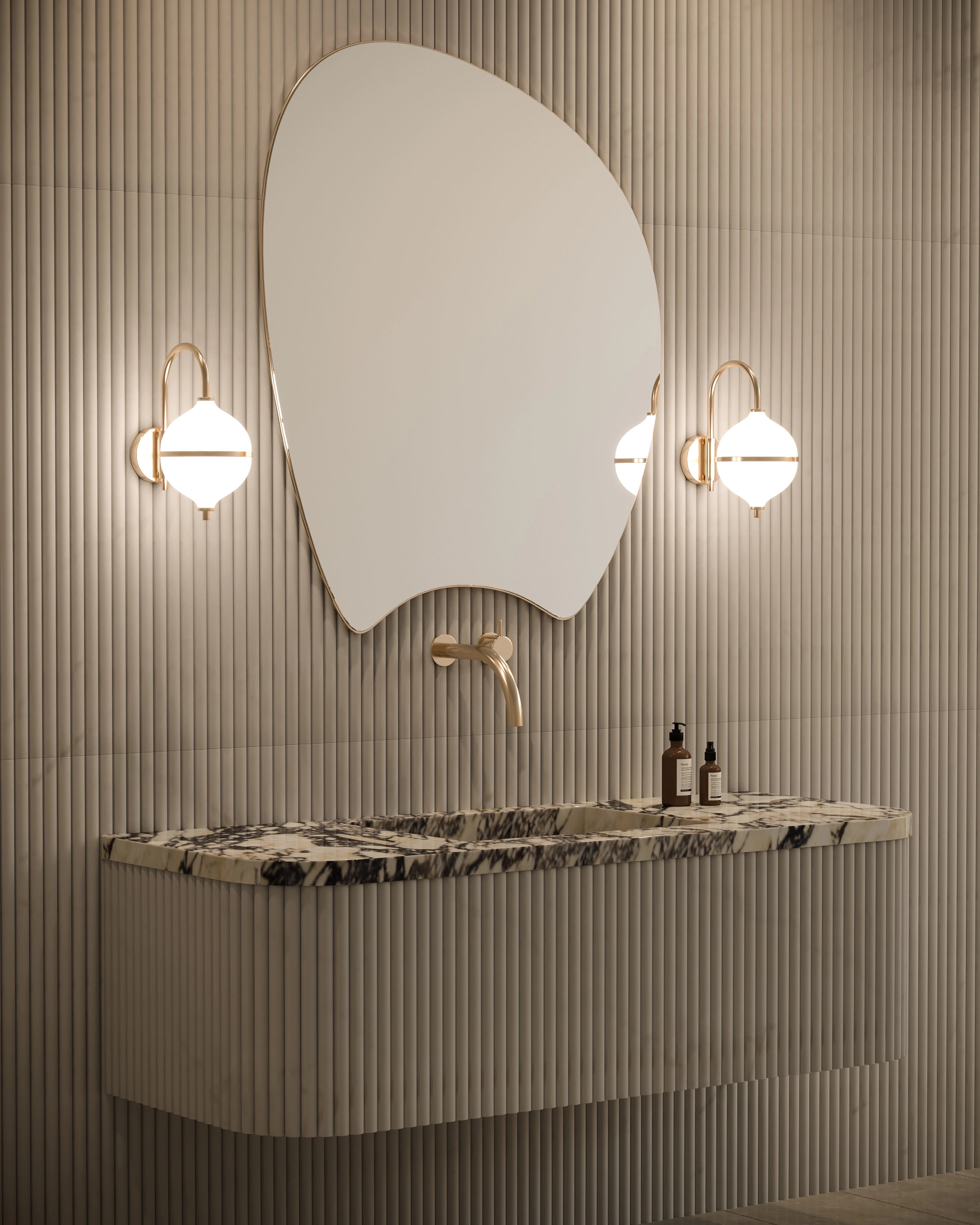 Modern bathroom vanity with marble countertop, round mirror, and wall lights.