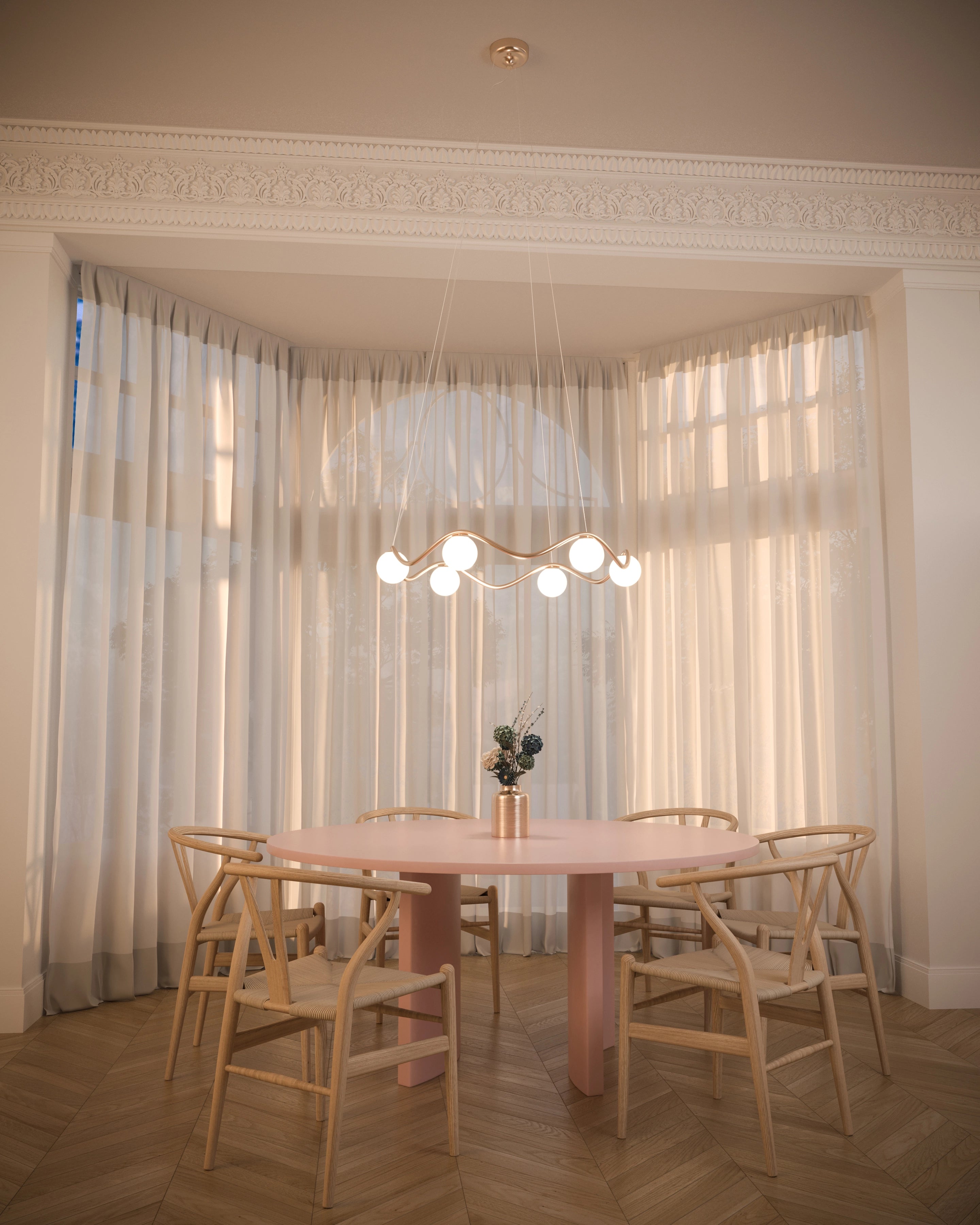 Dining room with a round table and chairs, large windows with sheer curtains, and a chandelier.